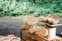 a vintage pie bar with a wooden shelf, vintage scales and cute stands with lots of delicious mini pies is cool