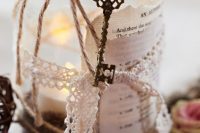 a wedding decorations of a jar with a candle, lace, twine, a vintage key and some acorns on the table is a great idea to rock