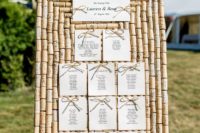 a wedding seating chart fully made of wine corks and with paper and bows is a cool and bold idea