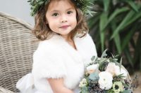 a white dress with a full tutu skirt, a white faux fur coverup and a textural greenery crown for a winter flower girl