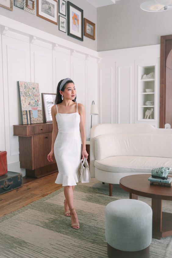 a white flare midi spaghetti strap dress, nude shoes, a white bag and statement earrings for a bold and cool look
