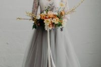 a white lace top with long sleeves and a grey tulle maxi skirt with a train for a modern and romantic bridal look