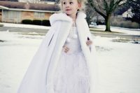 a white maxi dress with a tutu skirt, a white faux fur cloack and a crown for a winter flower girl look