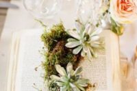 an open book with moss and succulents is a cool idea for a book lover wedding