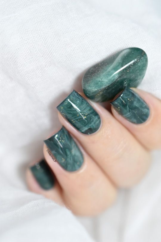 beautiful malachite inspired nails with marbleizing touches and glitter look fantastic and very edgy