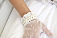 delicate white lace gloves with polka dots, ruffles and two rows of pearls for a refined feel