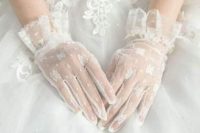 elegant white mesh gloves with ffloral appliques and wide ruffles on the wrists look chic