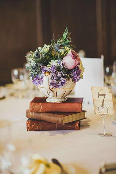 placing your floral centerpiece on a book stack will allow you to make smaller arrangements and save some money on that