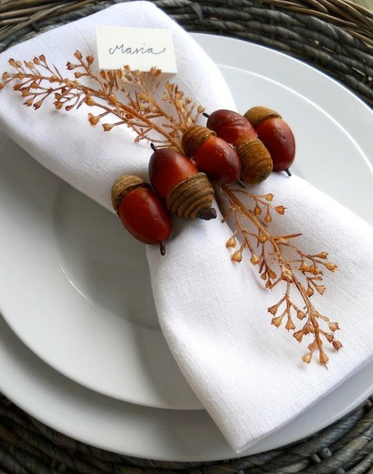 white plates paired up with a crispy white napkin and a bold faux acorn napkin ring with a dried branch for a fall wedding