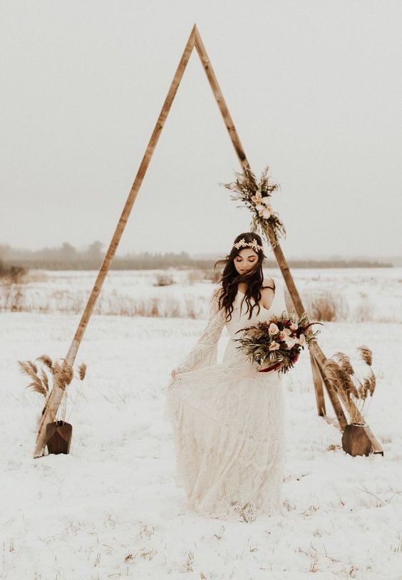 a boho lace A-line wedding dress with a floral crown and a bold wedding bouquet for a winter wedding