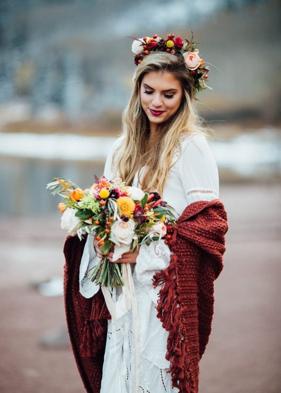 a boho lace wedding dress with ruffled sleeves, a burgundy fringe coverup, a lush floral crown