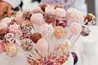 a bowl filled with confetti and lots of delicious and fantastic cake pops for a bright modern wedding