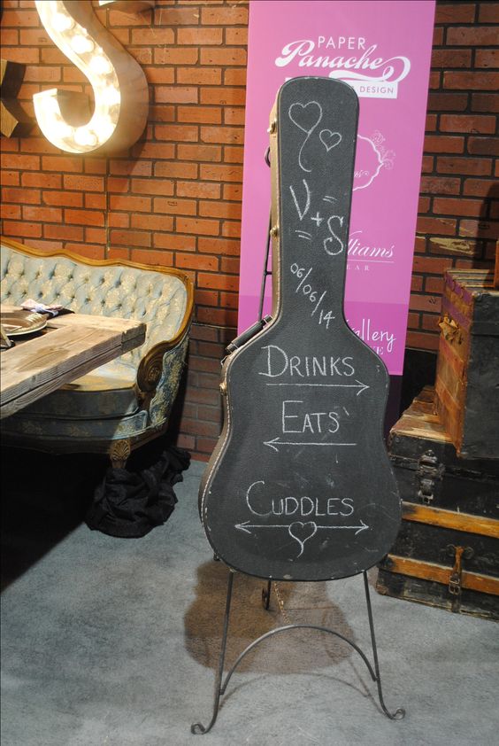 a chalkboard guitar case can be used instead of usual wedding signage, it's a very creative idea