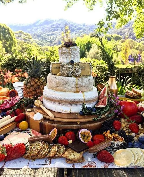 a cheese tower for a tropical wedding displayed with fresh fruit, berries and crackers is a gorgeous idea