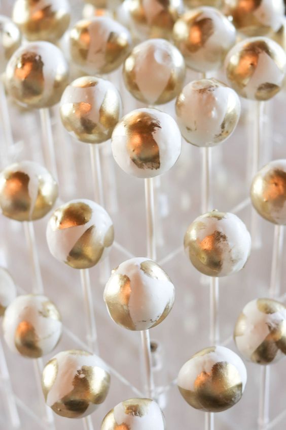 a clear acrylic stand with white and gold cake pops is a gorgeous idea for a modern glam wedding, they are very crowd-pleasing