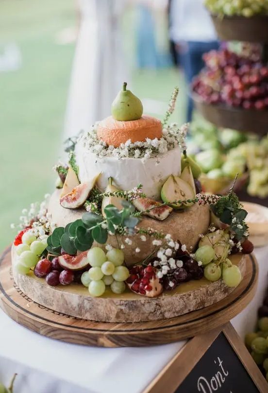 a cute cheese tower with baby's breath, eucalyptus, grapes and pears is a great idea for a relaxed summer wedding
