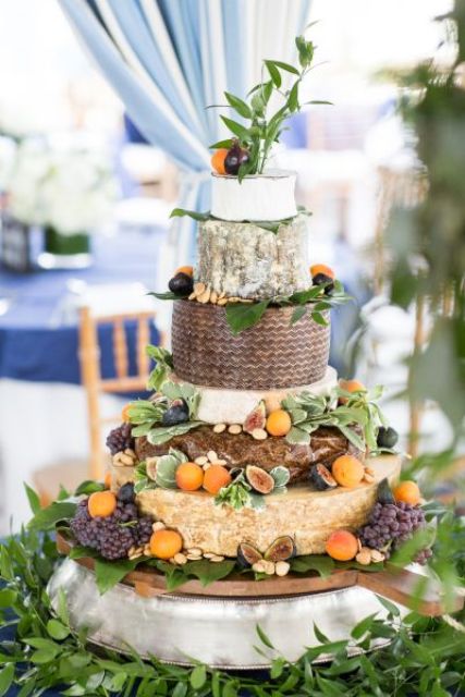a fantastic cheese wheel wedding cake topped with greenery, fresh figs, grapes and fruit is a lovely idea for a bold fall wedding