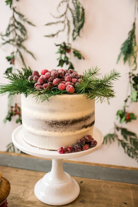 a gingerbread naked wedding cake with evergreens and sugared cranberries is a classy rustic wedding cake for Christmas celebrations