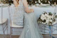a grey lace A-line wedding dress with no sleeves, cutout back and a train for a very refined winter bridal look