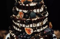a naked chocolate wedding cake with figs, grapes, gilded blackberries and chocolate drip