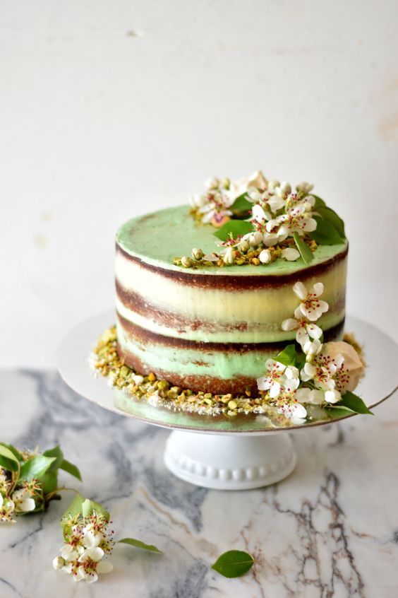 a naked green pistachio wedding cake topped with pistachios and fresh white blooms for a lovely spring wedding