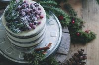 a naked wedding cake topped with pinecones, fir branches and sugared berries is a stylish idea for a Christmas wedding