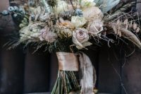 a neutral boho winter wedding bouquet with herbs, blush roses, white blooms, dried blooms and dusty pink ribbons