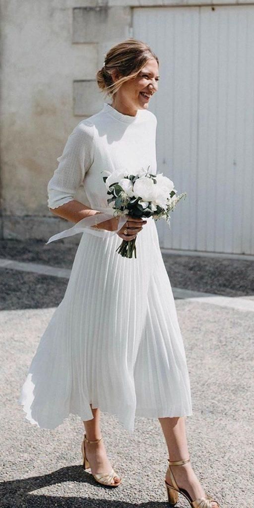 a pleated A line midi wedding dress with a high neckline plus gold heels for a casual and chic bridal look