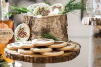 a rustic sweets bar with birch stumps and branch stands and wood slice trays and holders for food and drinks