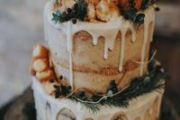 a rustic winter wedding cake with creamy drip, evergreens, privet berries and donuts here and there