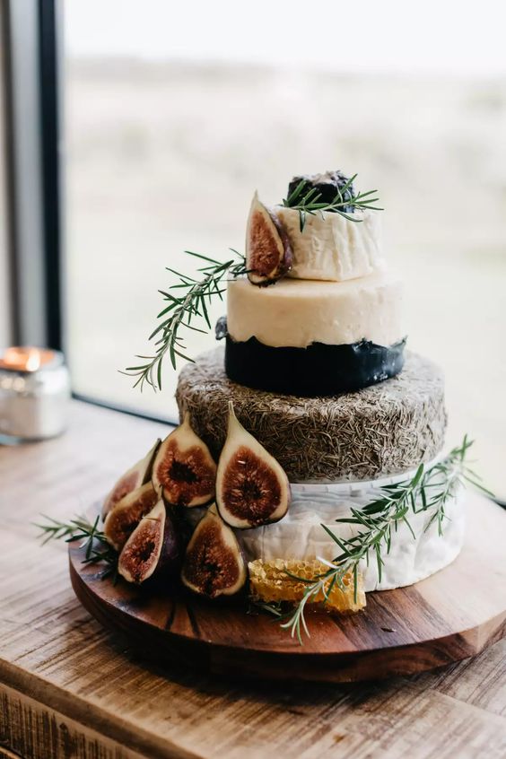 a small and pretty cheese wheel wedding cake topped with fresh figs, honey combs and herbs is a lovely idea for a refined decadent wedding