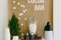 a small yet stylish hot chocolate bar with hanging marshmallows, a little tree, some syrups and some toppings