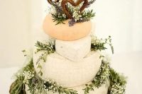 a wild and natural cheese wedding cake decorated with garden grown lavender and herbs, wicker letter toppers