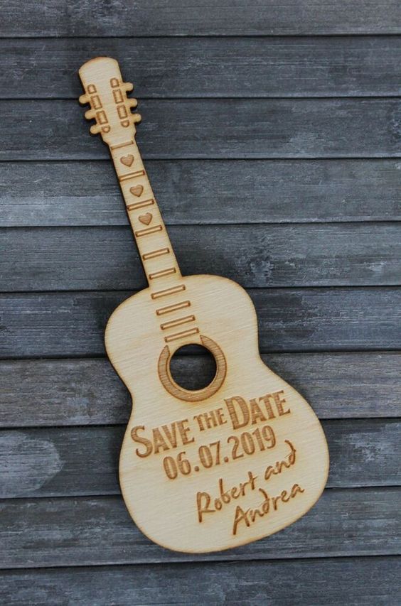 a wood burnt save the date shaped as a guitar is a lovely and fun idea for a music-loving couple