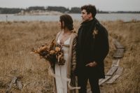 boho winter wedding attire – a silk A-line wedidng dress with a chunky cardigan, a total black look with a coat for the groom