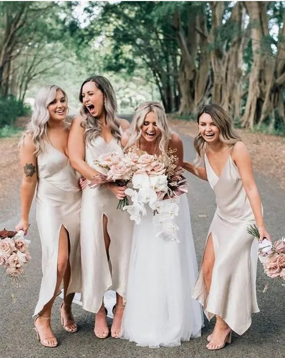 comfy and cool neutral slip midi bridesmaid dresses with front slits and V-necklines plus nude heels for a spring or summer wedding