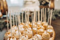 delicious cake pops placed on a wood slice are amazing for a rustic wedding, such a display is great