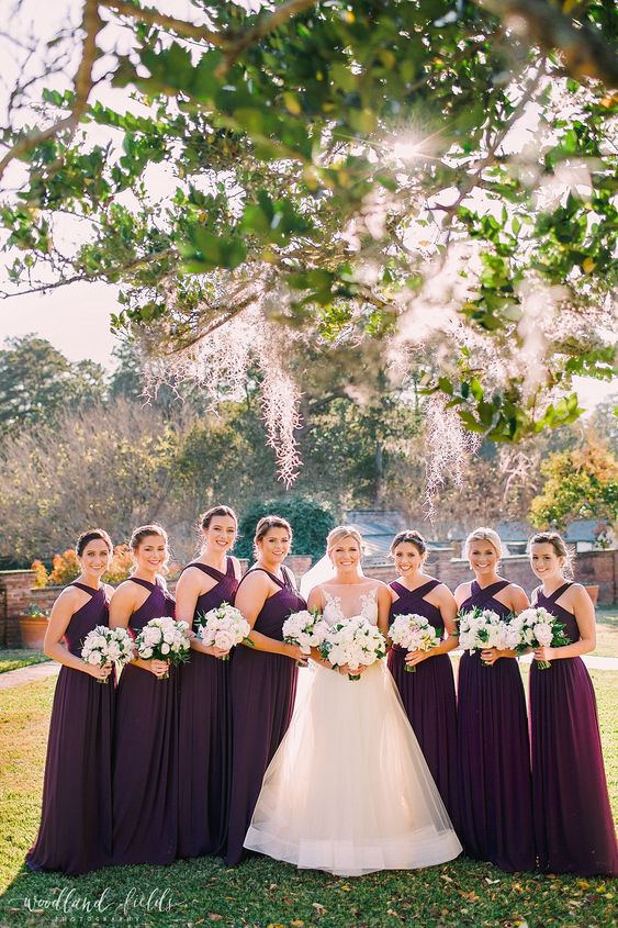 elegant purple maxi bridesmaid dresses with criss cross necklines and pleated skirts are a gorgeous idea for the fall