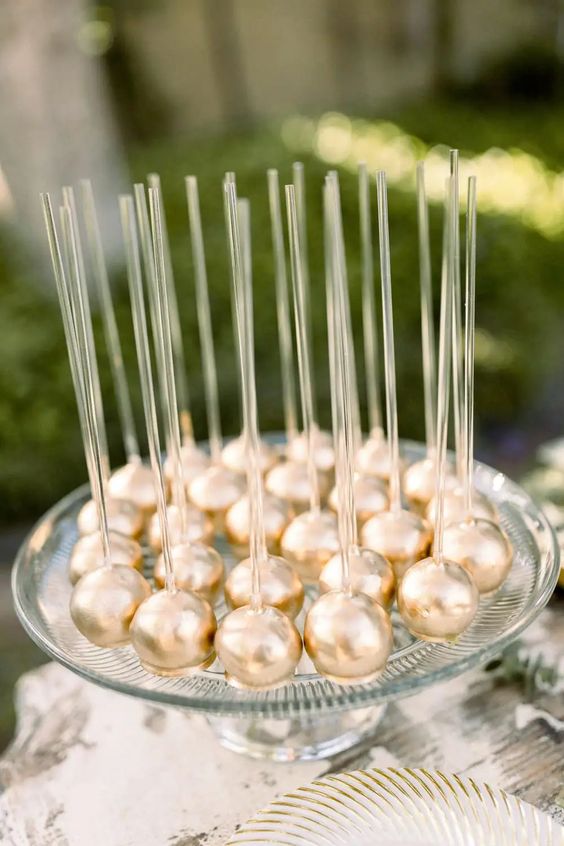 gold cake pops with clear sticks are a perfect idea for a glam wedding with metallic touches