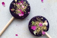 gorgeous dark lollipops with flower petals and gold are amazing for any wedding, they look bold and elegant