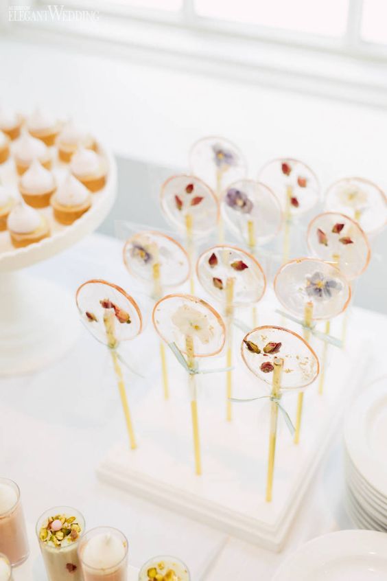 very delicate and cute blush lollipops with dried blooms and dusty blue bows are amazing for a pastel spring or summer wedding
