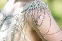 shiny shoulder jewelry with neutral and pink rhinestones and various rhinestone chains hanging is super glam and chic