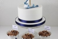 a white wedding cake with navy ribbons and fun cream snowboards on top for a bright look