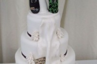 a fun white wedding cake with edible ribbons and black touches plus a fun edible cake topper with snowboards