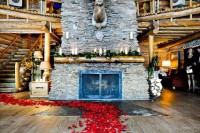 greenery and candles on the mantel and red petals on the floor to accent the fireplace as a ceremony backdrop
