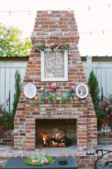 a working fireplace with frames, bright blooms and greenery for a chic and bright look in your wedding lounge