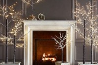a fireplace surrounded with pre-lit trees in pots will create a winter fairy tale feel in the space