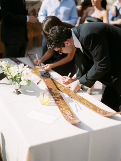 guests leaving wishes and their names on large skis - this is a great idea for a ski resort wedding