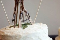 a textural buttercream wedding cake topped with greenery, skis and other ski stuff is a very beautiful and cozy dessert for a ski resort wedding