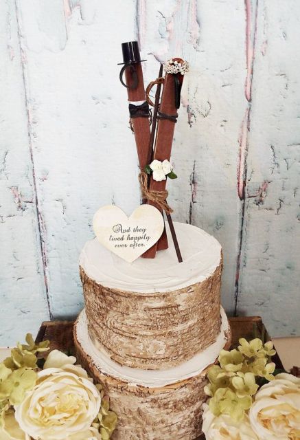 a bark wedding cake topped with a heart and with skis in a veil and a top hat is a whimsy and fun wedding cake for your ski resort wedding